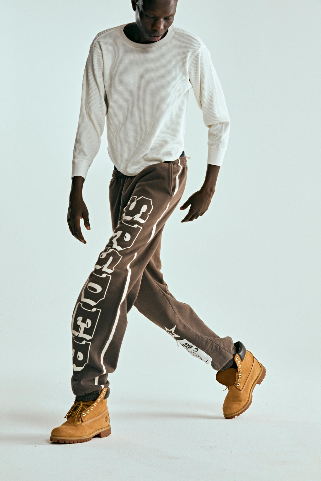 Brown 5STAR RODEO SWEATPANT with white SP5DER text print, side stripe, and distressed patch.