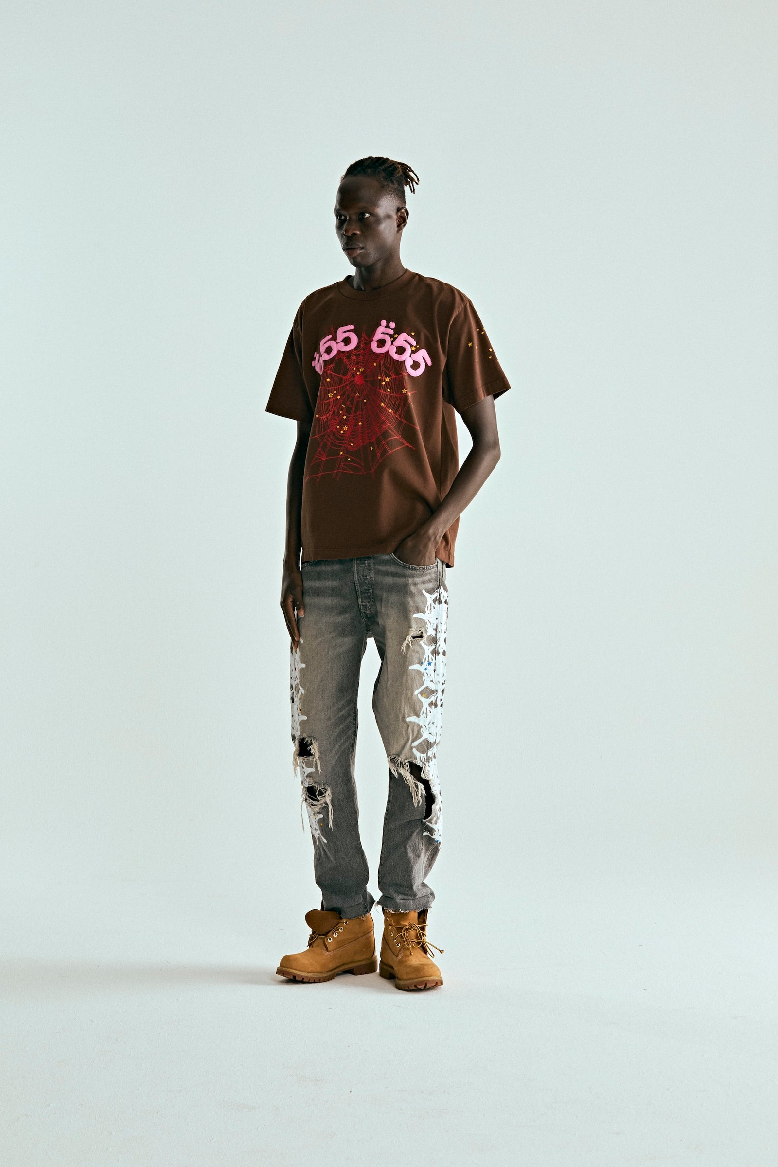 Model wears brown 100% cotton ANGEL NUMBER TEE with pink '555' and web puff/discharge print.