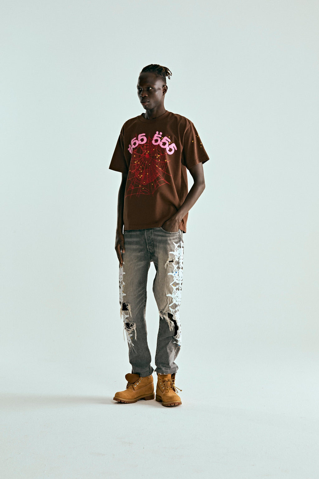 Model wears brown 100% cotton ANGEL NUMBER TEE with pink '555' and web puff/discharge print.