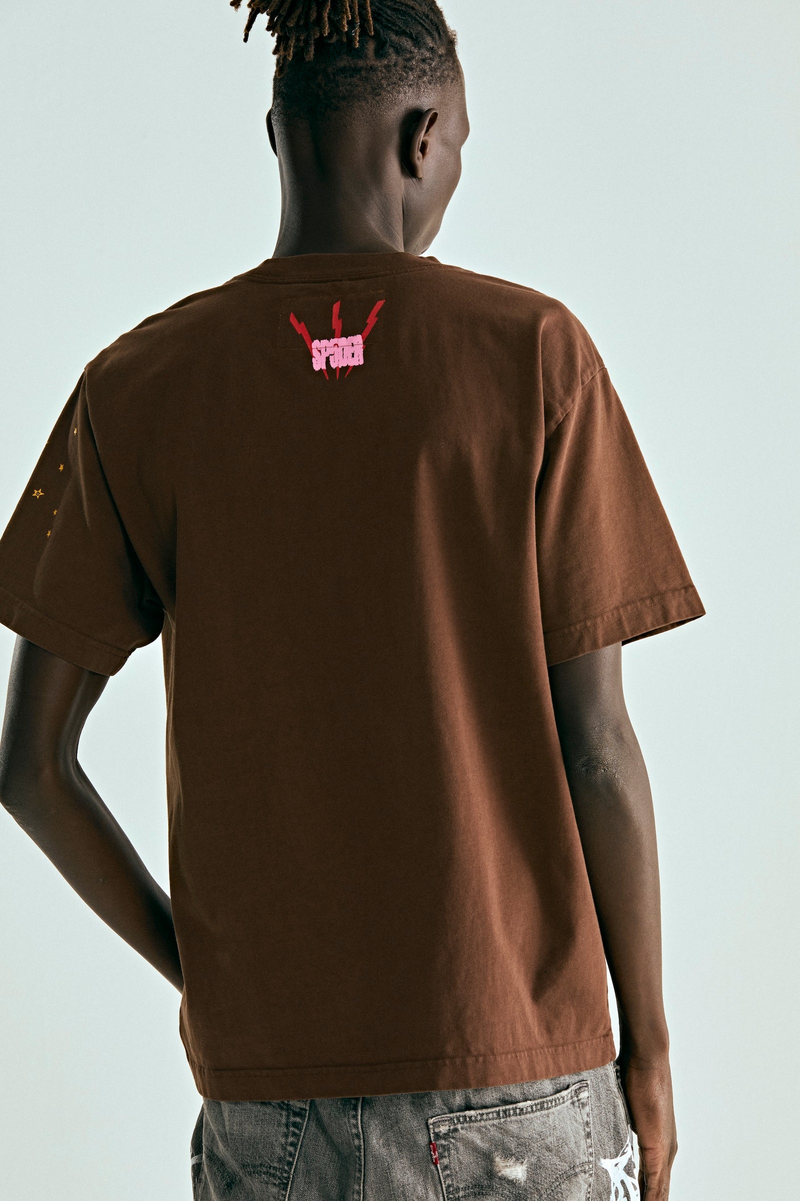 Back of a brown cotton tee with a red "SPIDER" puff print logo on the upper back.