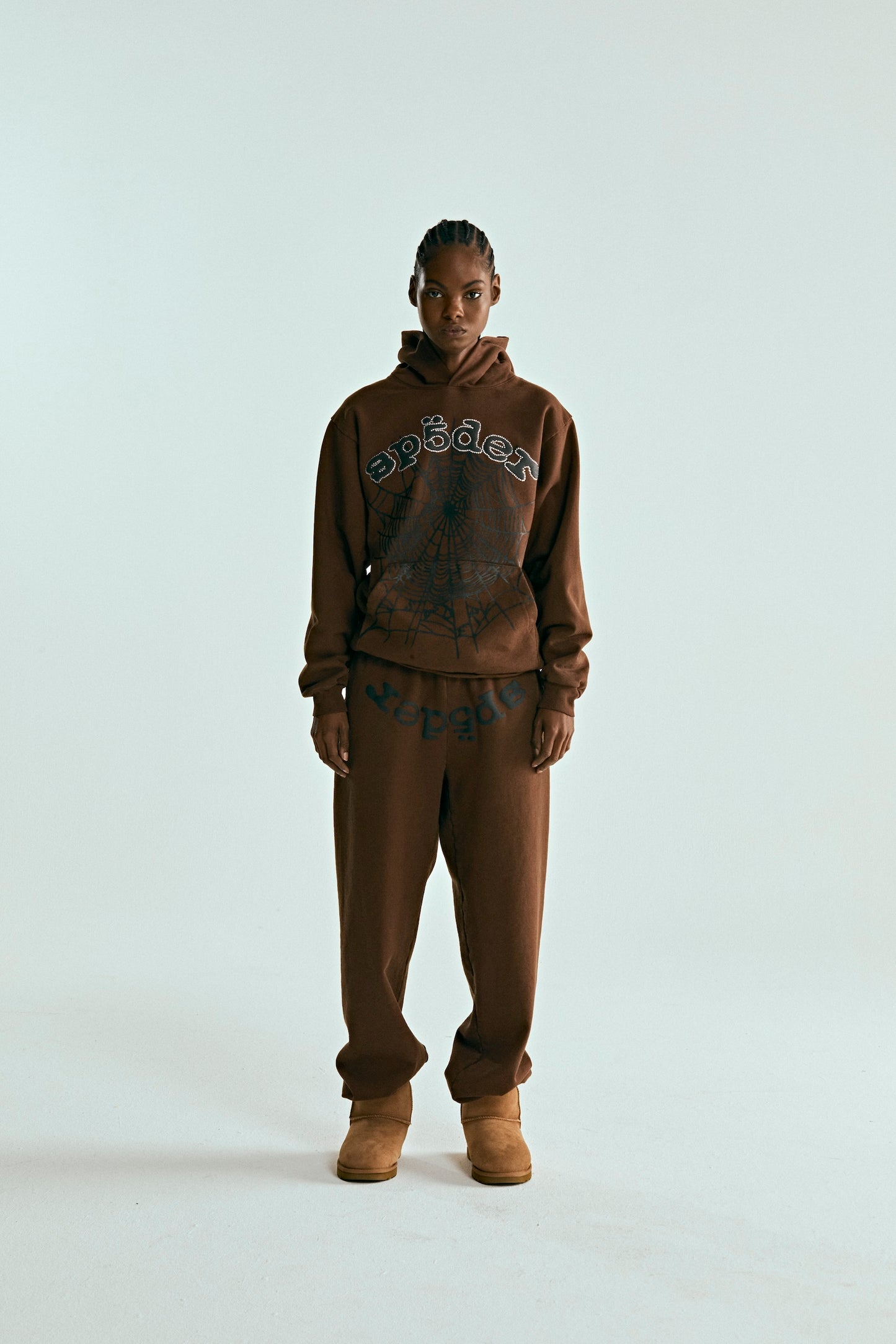 Brown cotton fleece hoodie with rhinestone "SP5DER" text and web print, paired with matching sweatpants.