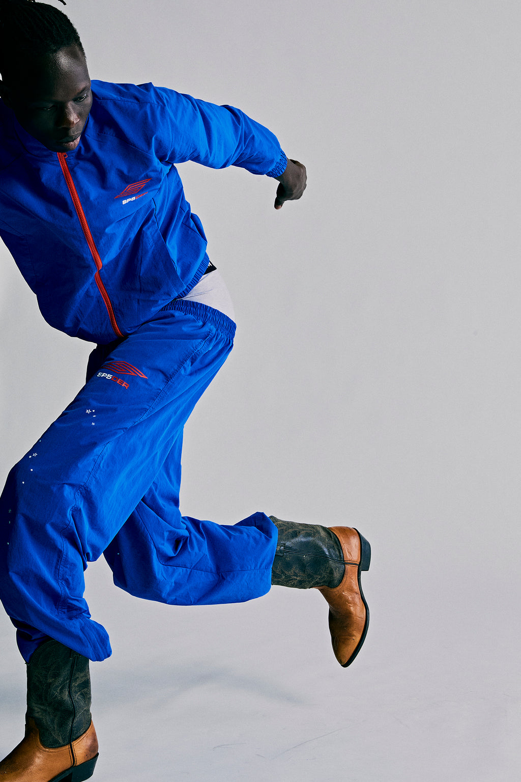 Blue nylon ripstop SP5DER PRO WIND PANT with logo, star print, and zip cuffs.
