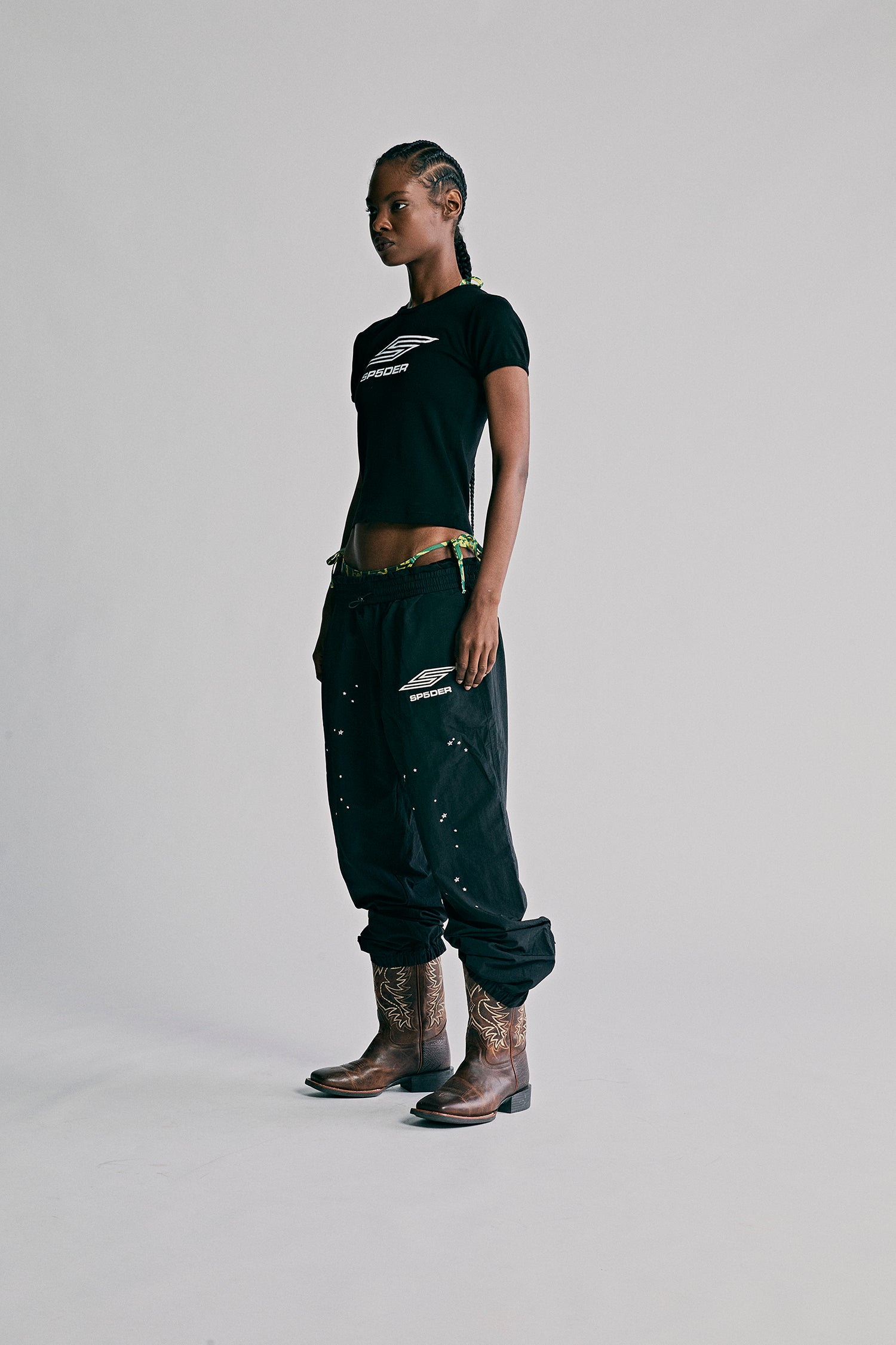 Black nylon ripstop SP5DER PRO WIND PANT with scattered star print, bungee drawstring, and zip cuffs.