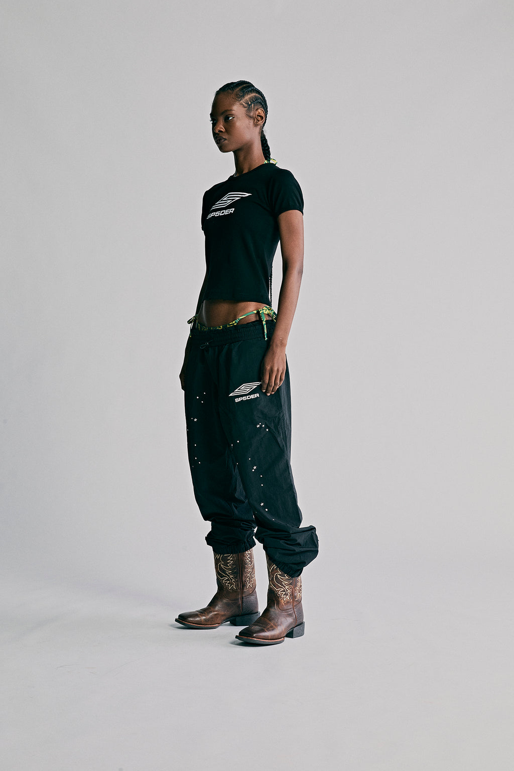 Black nylon ripstop SP5DER PRO WIND PANT with scattered star print, bungee drawstring, and zip cuffs.