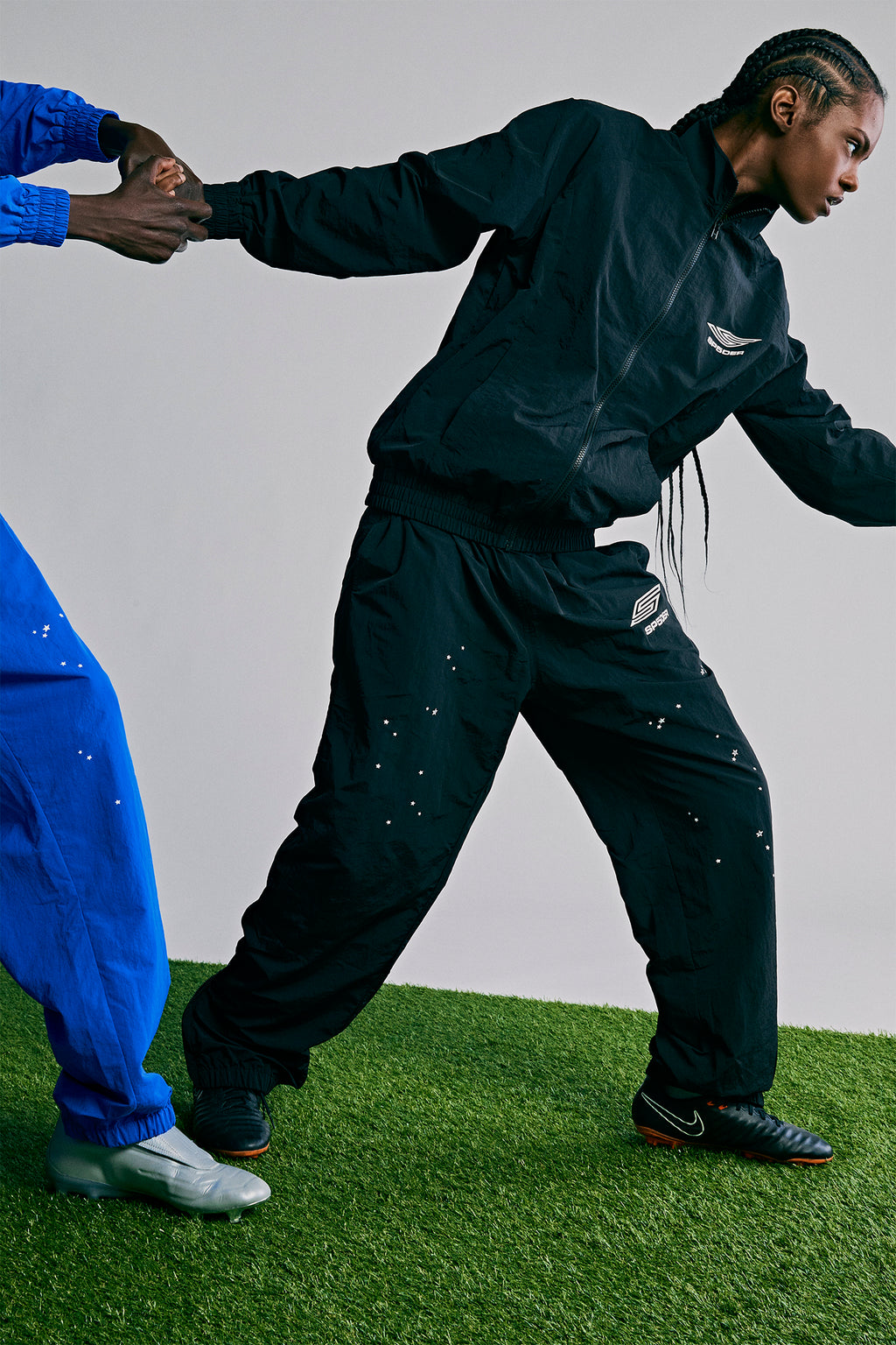 Black SP5DER PRO WIND PANT with scattered star print, nylon ripstop, and zip cuffs.