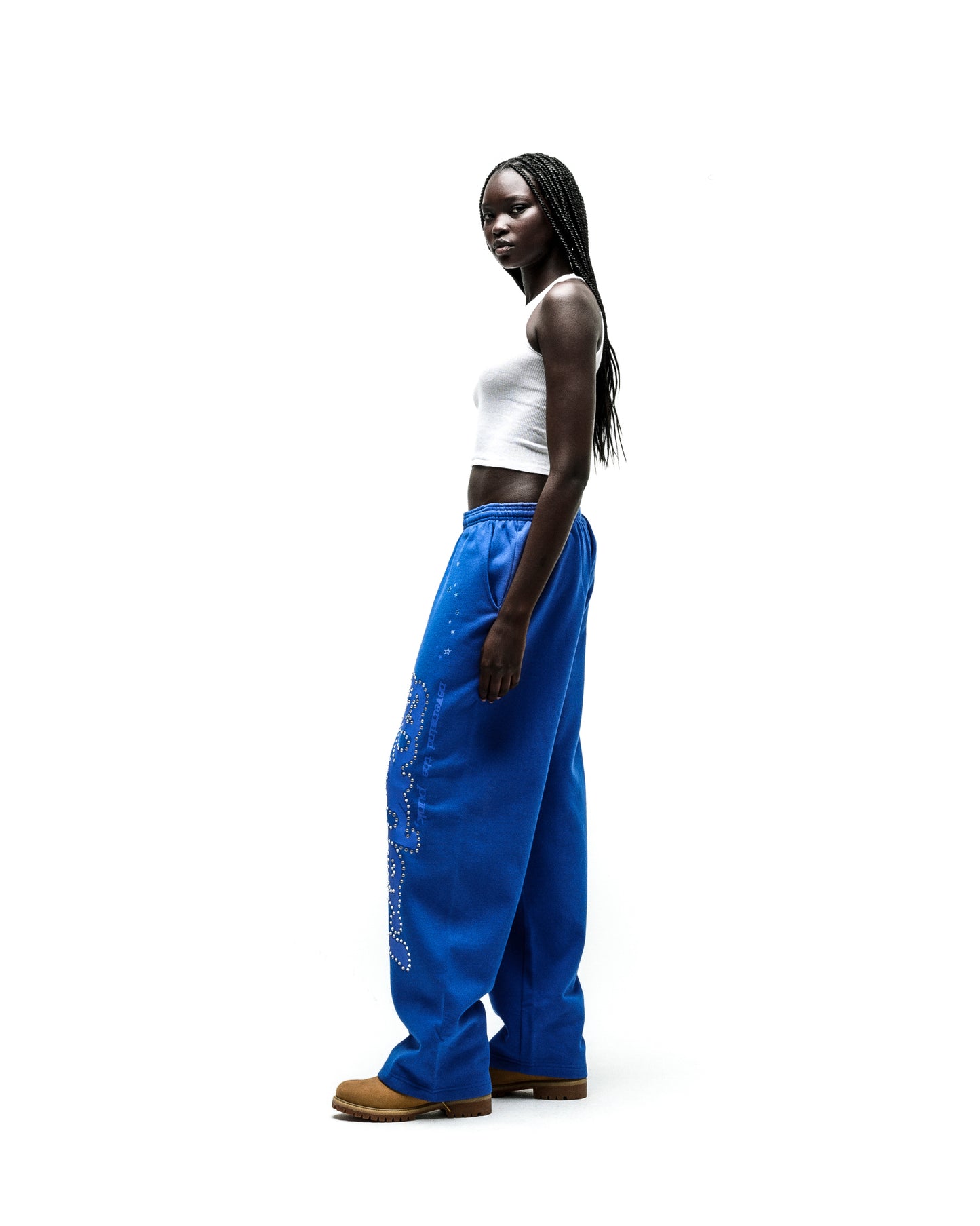 Model wearing blue RHINESTONE PUNK V2 SWEATPANTS with rhinestone P*NK SP5DER text and scattered stars.