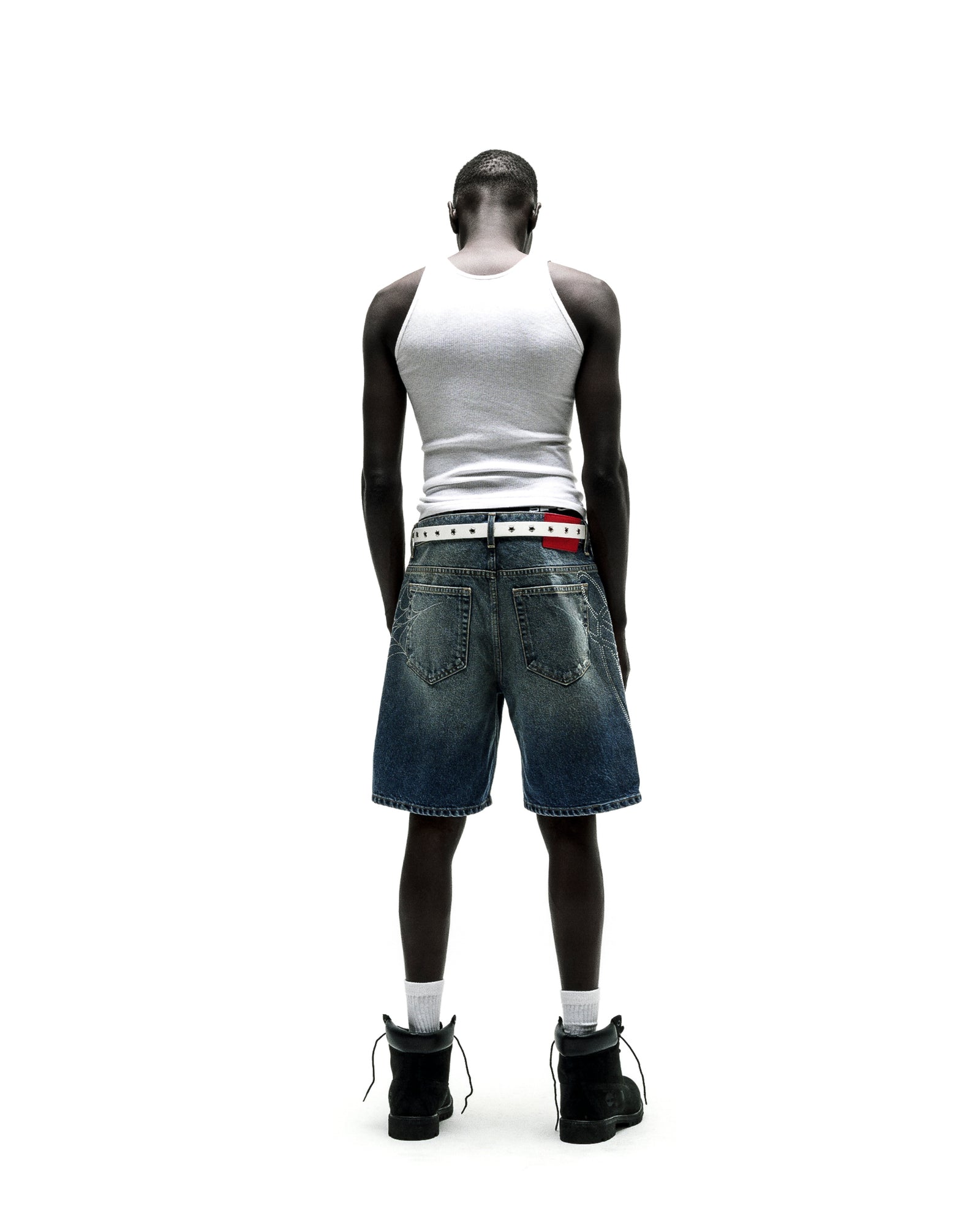 Vintage wash denim shorts with rhinestone web and text design, belt loops, and five-pocket styling.