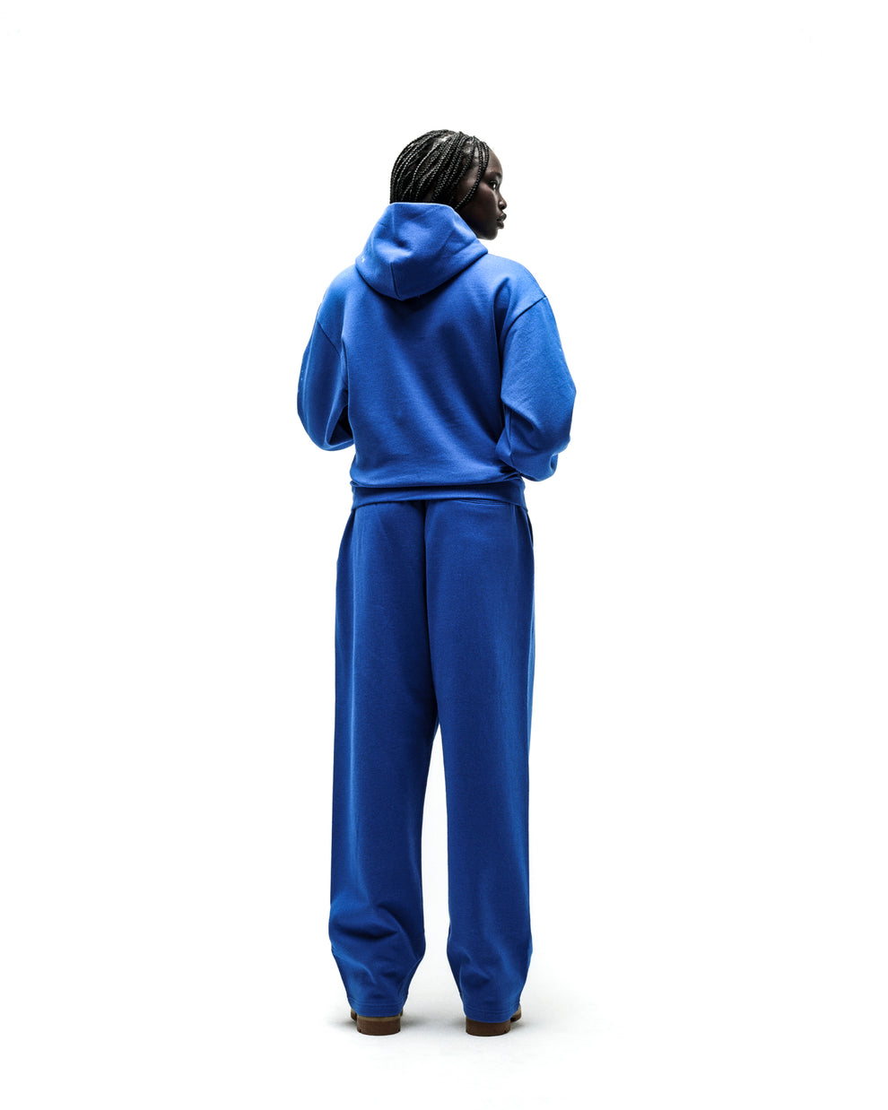 Model wearing a blue RHINESTONE PUNK V2 HOODIE and matching sweatpants, seen from the back.