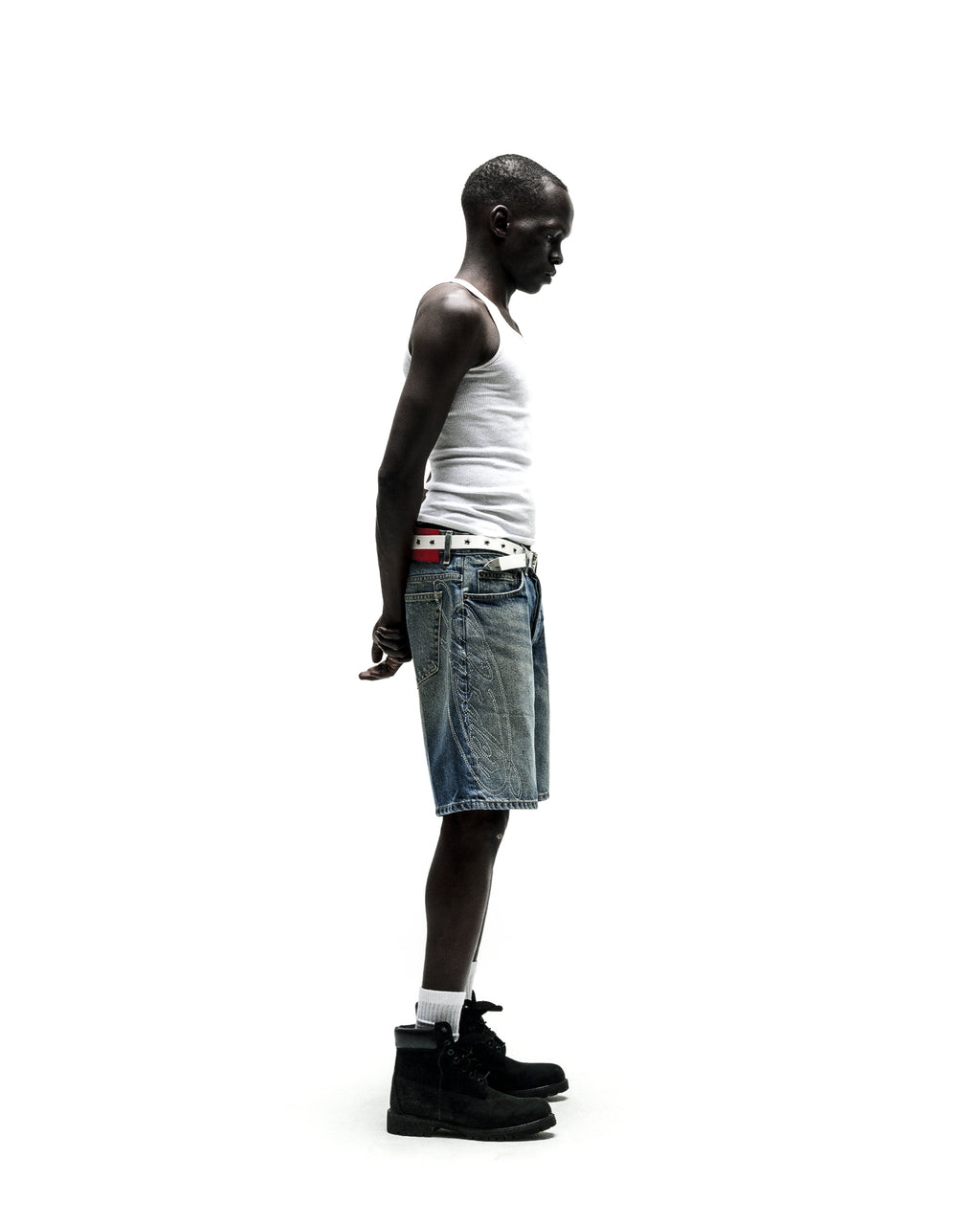 Man in vintage wash denim shorts with belt loops, five-pocket styling, and branded hardware.