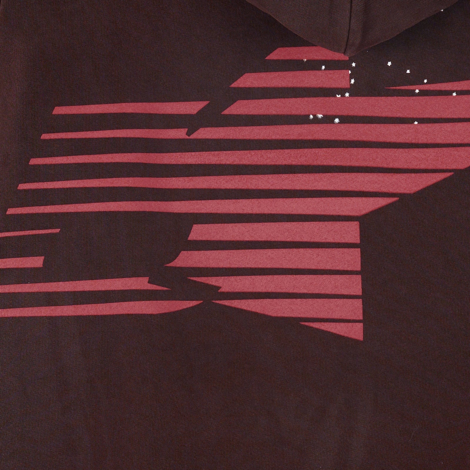 Close-up of a dark brown 23oz fleece hoodie with a red graphic print and small white stars.