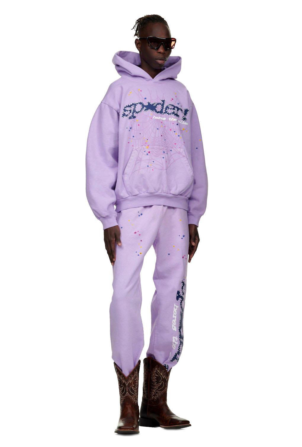 Male model in AÇAÍ SP5DER HOODIE and sweatpants, light purple 23oz fleece with puff/discharge spider web and star prints.