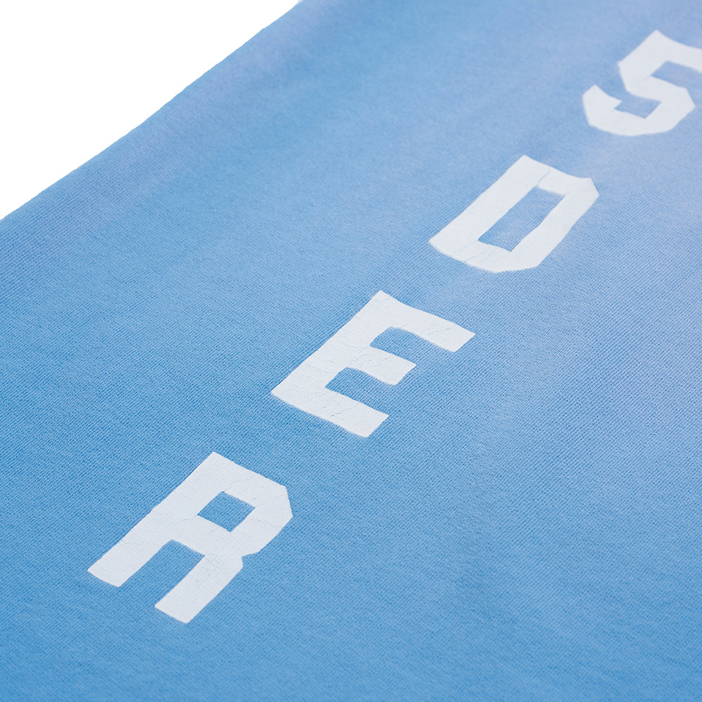 Light blue JUMBO SWEATPANT with white "SP5DER" print, showing sun fade wash on French terry fabric.
