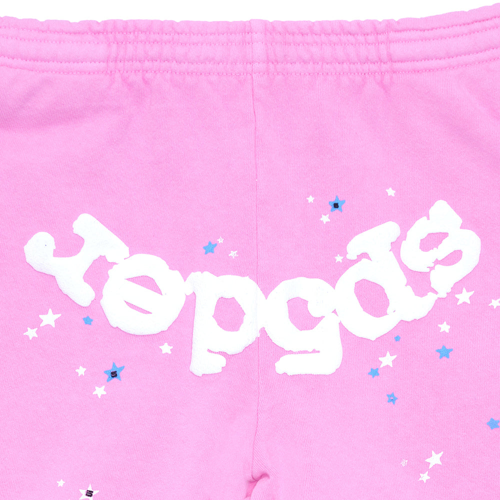 Pink fleece sweatpant with white "Sp5der" puff print and scattered white and blue stars.