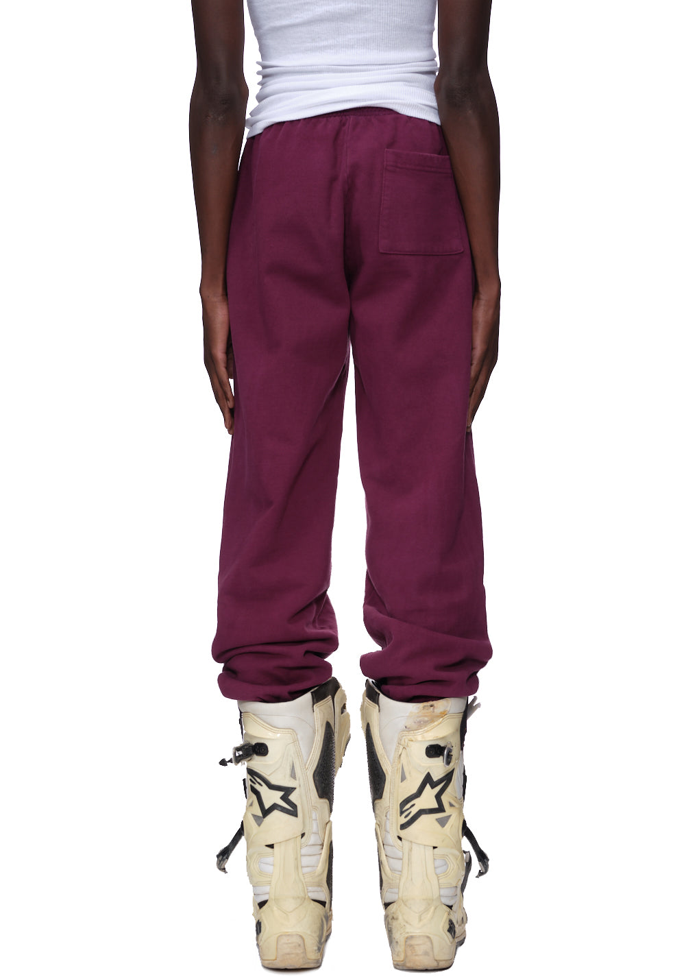 NOCTURNAL HIGHWAY SWEATPANT in deep burgundy 23oz fleece, featuring a back pocket and worn with white boots.