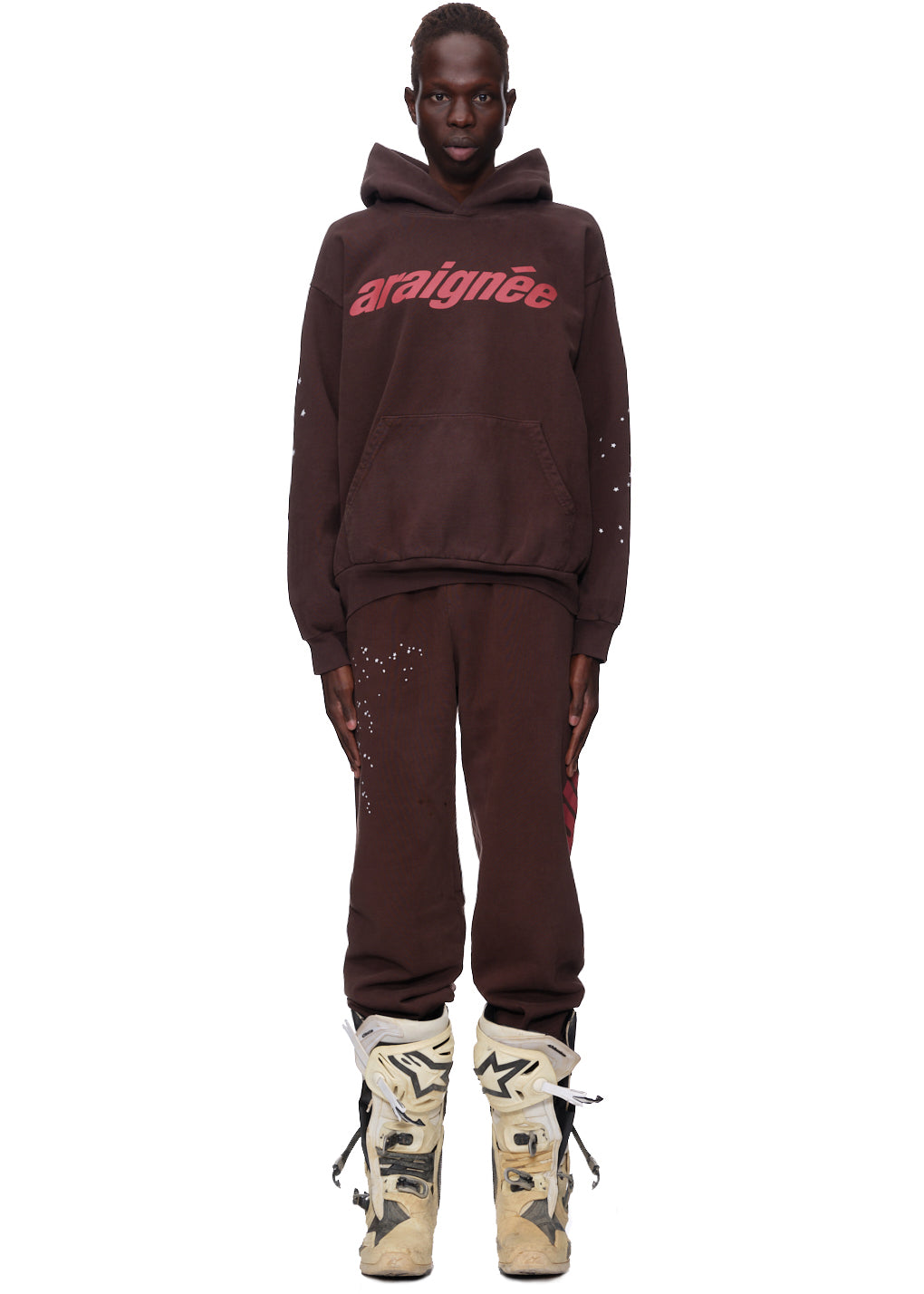 Brown ARAIGNEE HOODIE and sweatpants with red 'araignée' puff print, star details, and front pocket.