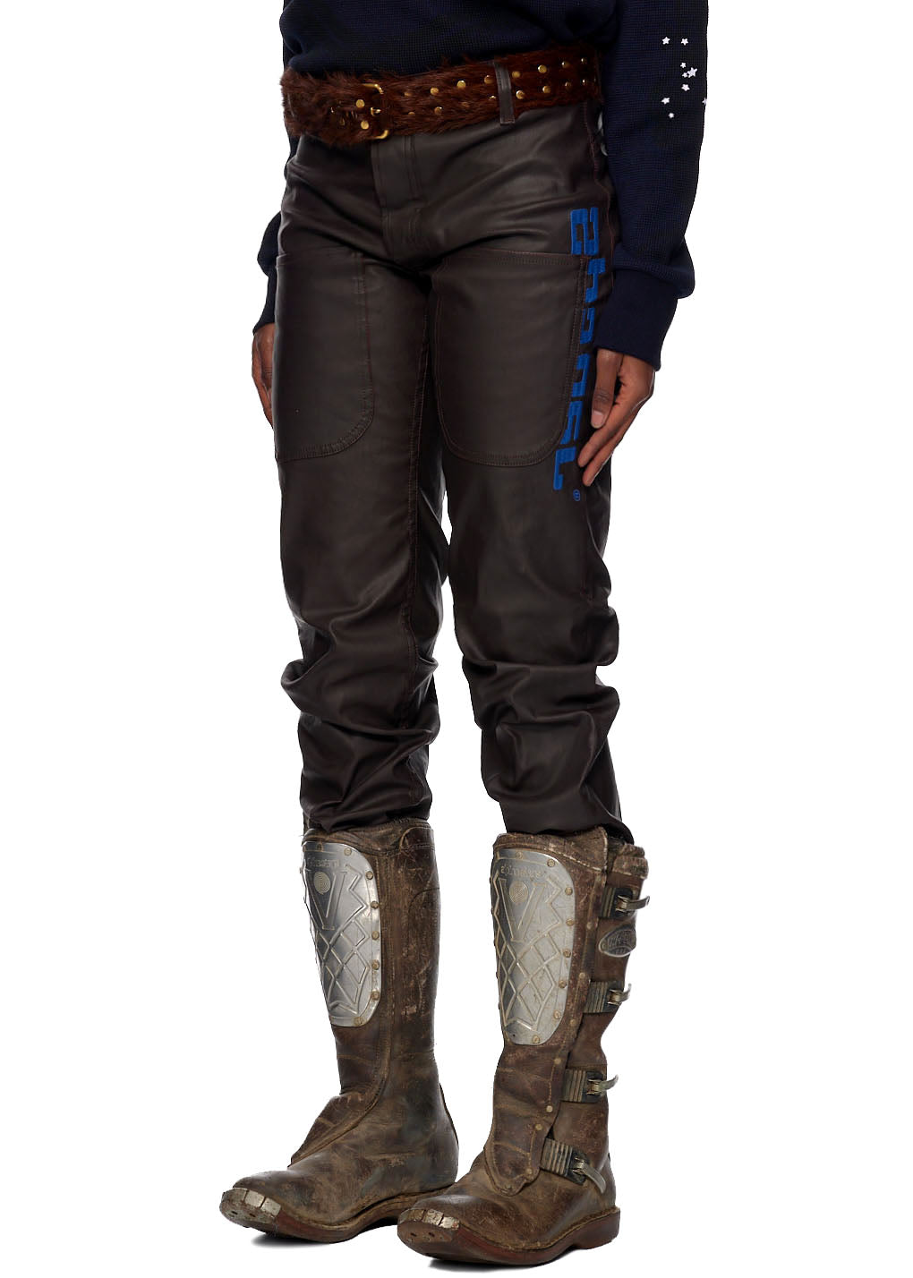 Brown coated canvas jeans with blue SP5DER branding, worn with brown boots.