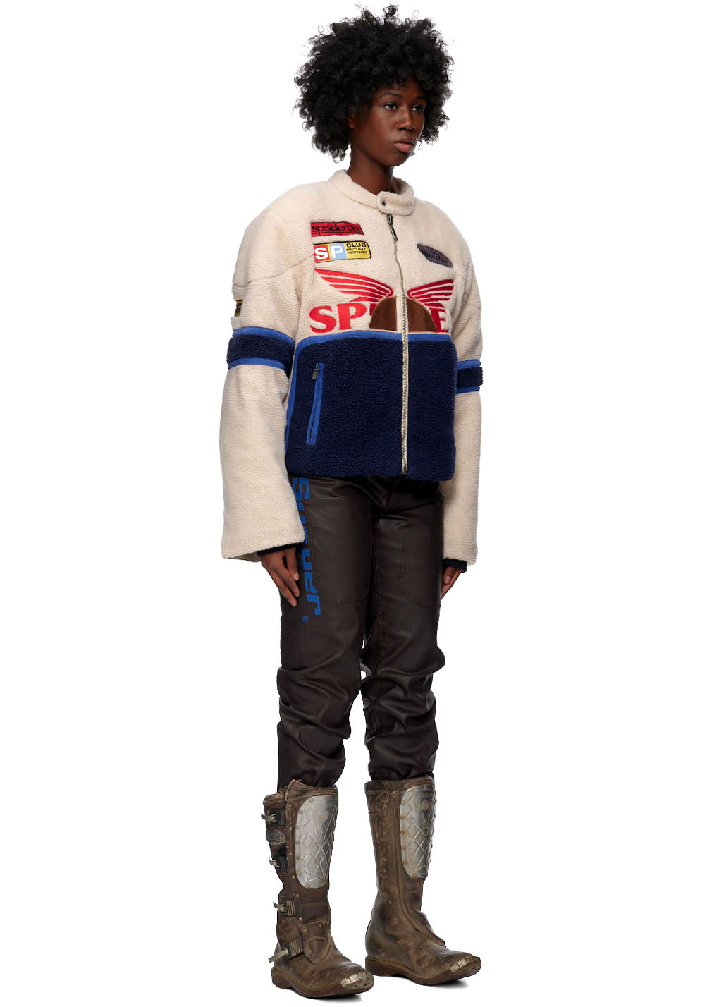 Sherpa Cafe Racer jacket with leather trim, SP5DER patches, and blue accents on a model.