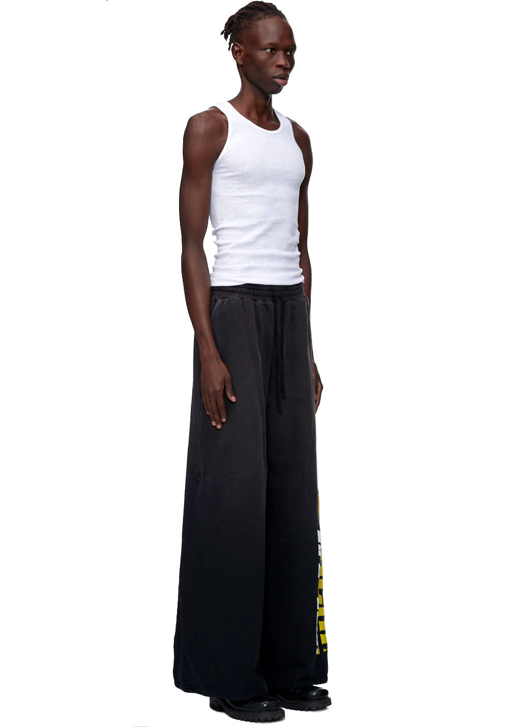 Model wearing vintage black 23oz French terry JUMBO SWEATPANTS with screen print down the leg.