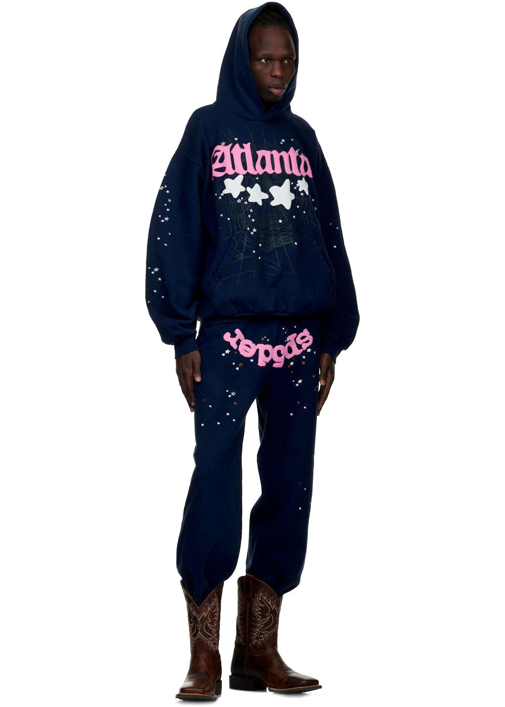Male model in navy fleece "Atlanta" hoodie and sweatpants with pink "Sp5der" print and white star/spiderweb details.