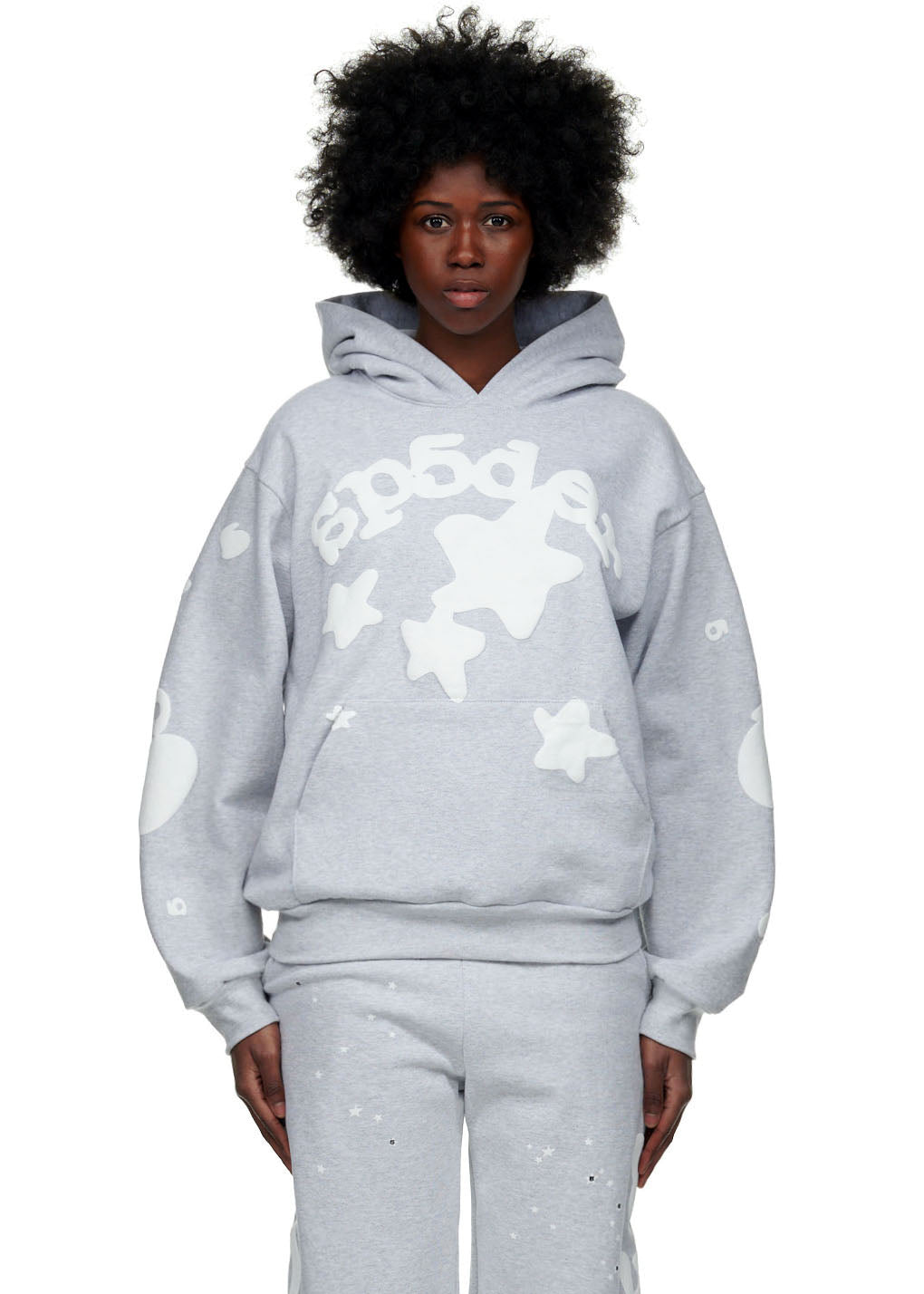 Female model in gray Beluga Hoodie with white 'SP5DER' and star puff prints.