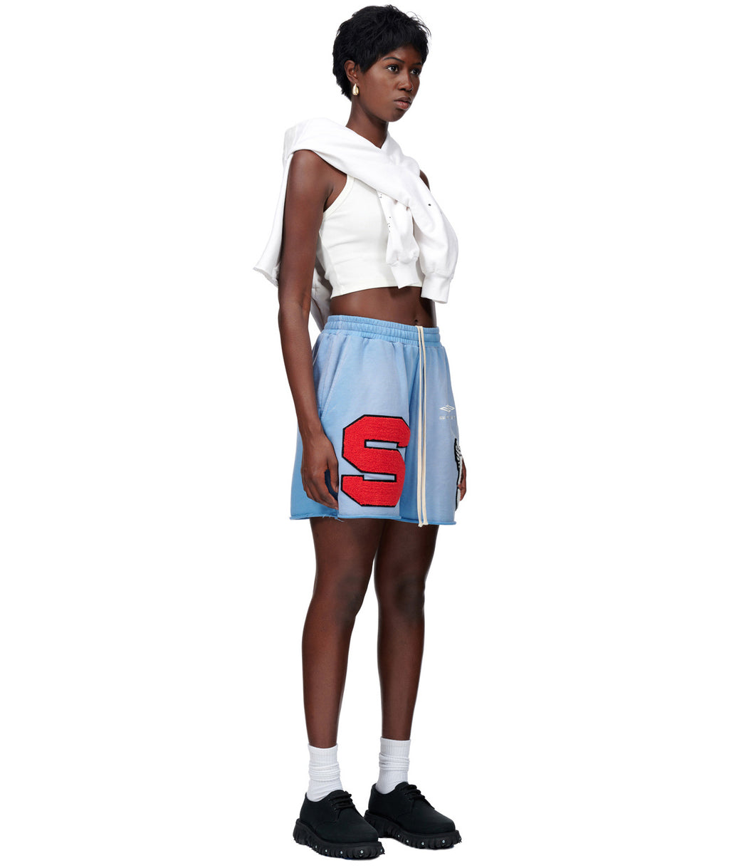Model wearing blue sun fade French terry CUT SWEATSHORT with red chenille 'S' patch and white drawstring.