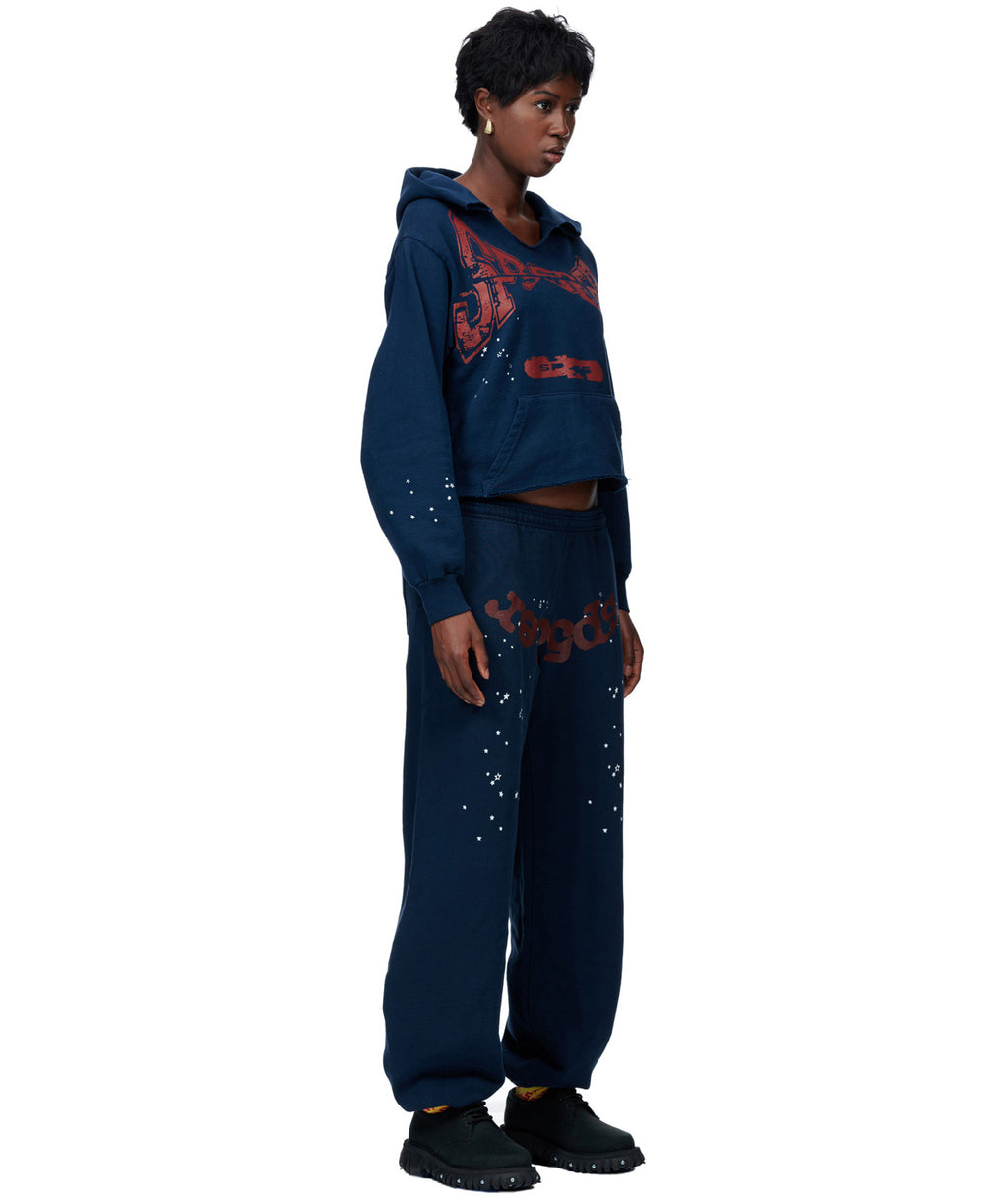 Navy blue cropped hoodie and sweatpants set with red puff print and white speckle details.