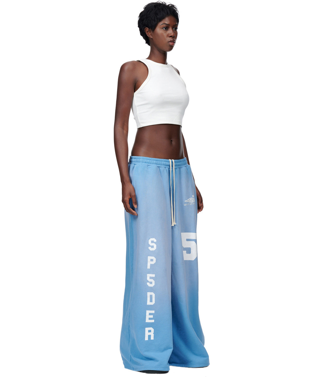 Model in JUMBO SWEATPANT, light blue French terry with SP5DER embroidery and vintage screen print.