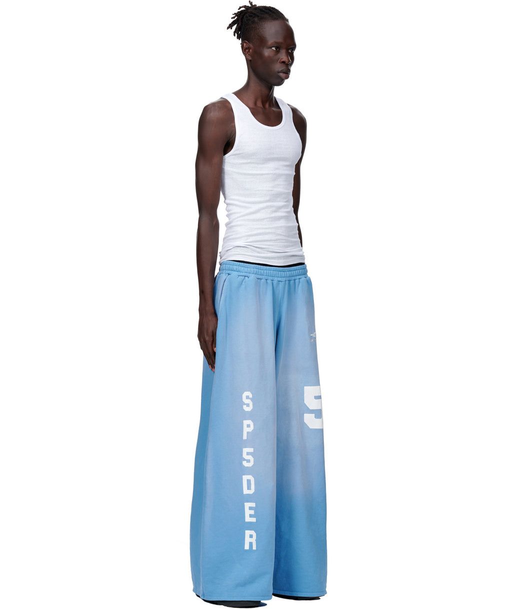 Model wearing JUMBO SWEATPANT in custom sun fade wash blue French terry with SP5DER embroidery.