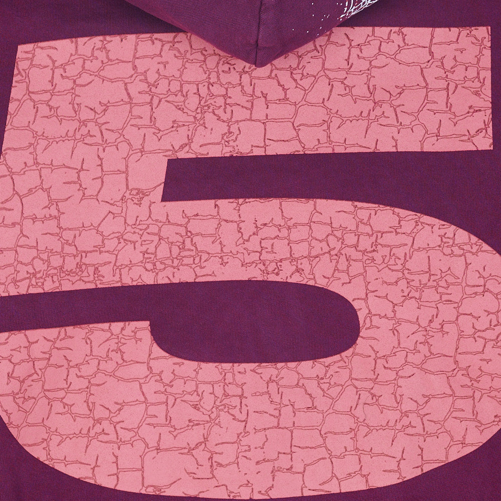 Close-up of a purple fleece hoodie with a large, cracked pink "5" graphic on the back.