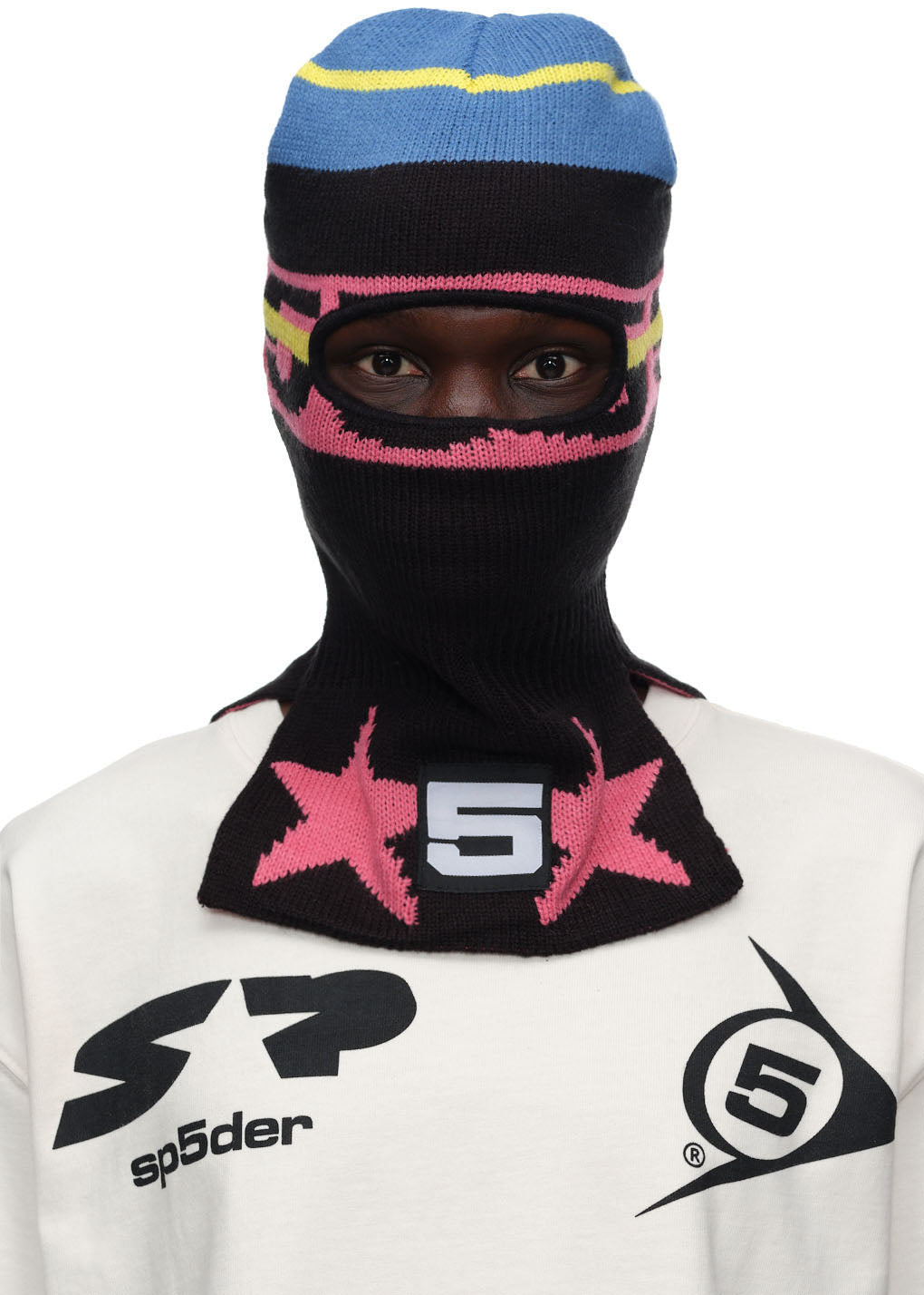 Black SP5DER balaclava with pink stars, white 5, and blue/yellow stripes.